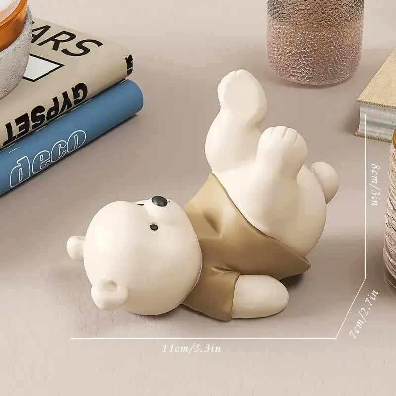 White ceramic bear cellphone stand featuring a cream bear figurine wearing beige shorts for desktop use