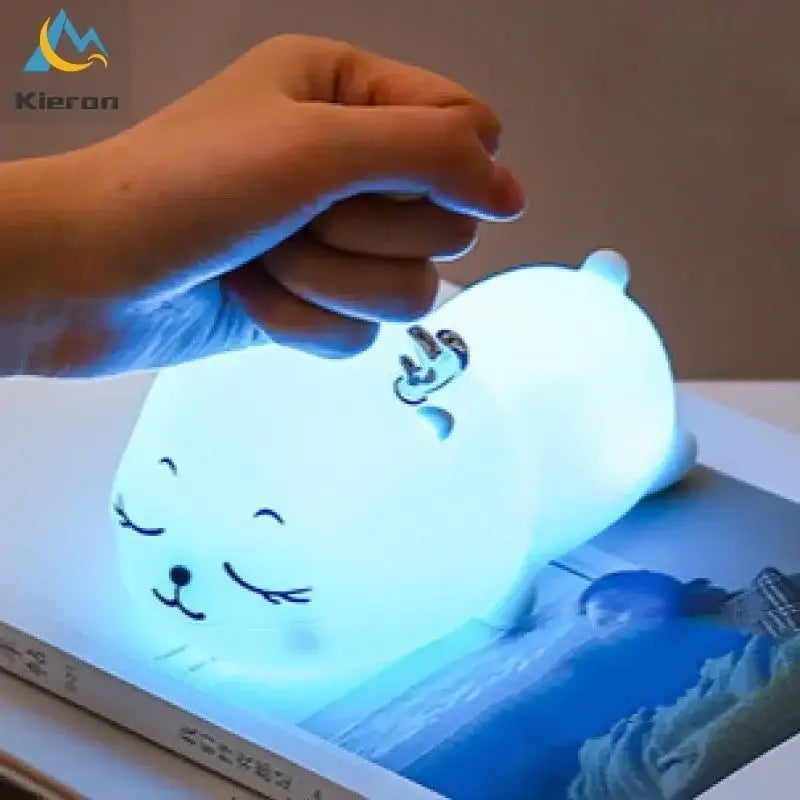 A soft glowing blue seal shaped night light with a cute face and crown detail perfect for decorbites colorful deer led lamp decor