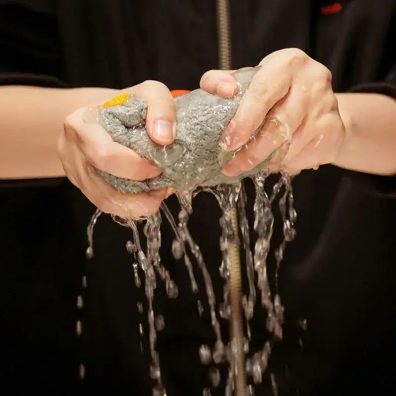 Gray textured sponge with yellow and orange handle squeezing water beside decorbites cute goose microfiber hand towels white and gray bathroom decor