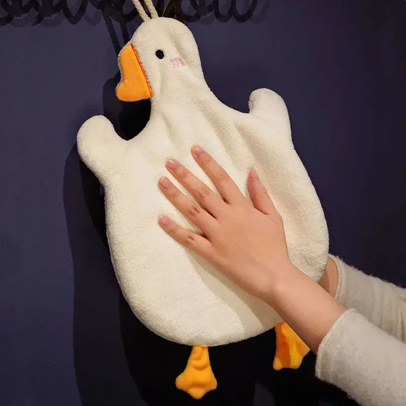 A plush white duck-shaped hot water bottle with orange beak and feet complements decorbites cute goose microfiber hand towels
