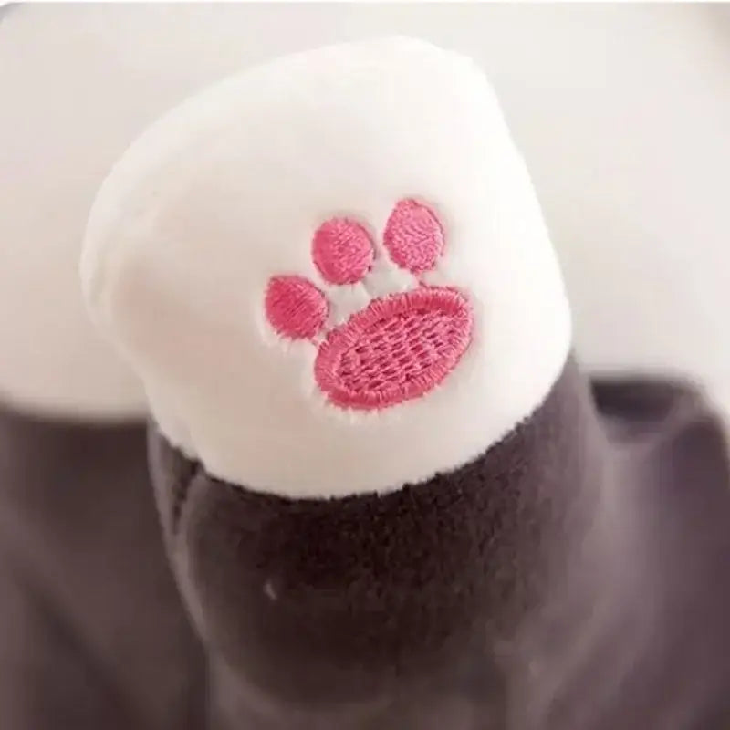 White plush cat paw toy with pink embroidered paw print shown alongside decorbites husky dog body pillow for bedroom decor