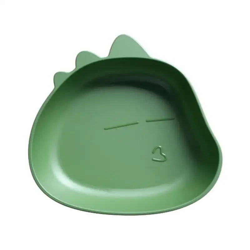 A matte green dinosaur shaped fruit plate with molded spikes and simple engraved facial features for children
