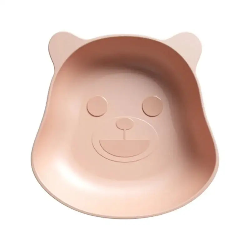 A soft pink bear shape plastic fruit plate with molded ears and smiling face for kitchen snacks