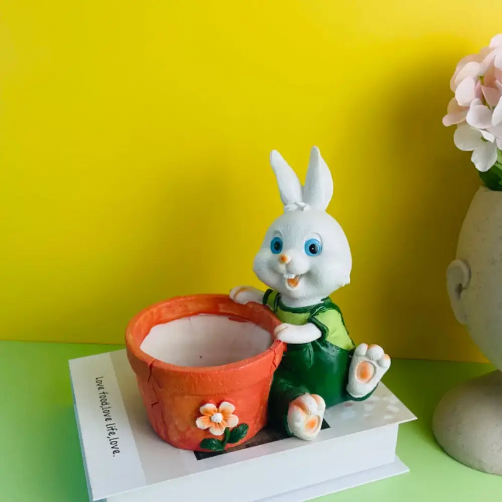 Cute white bunny rabbit flower ceramic pot with green overalls holding an orange flower decorated garden decor