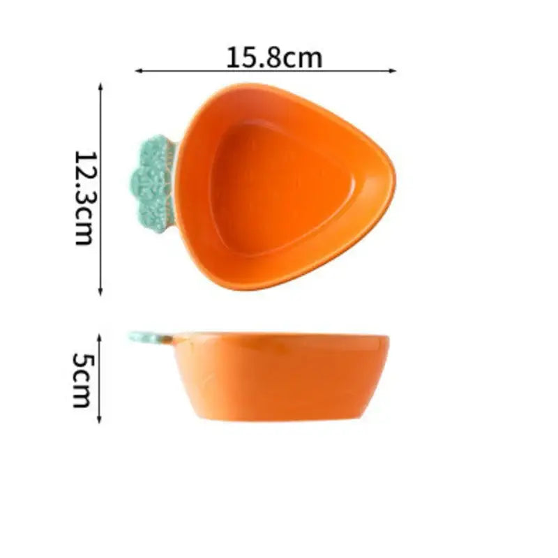 Orange ceramic carrot-shaped bowl with light green leafy top in a ceramic tableware set for dining room use
