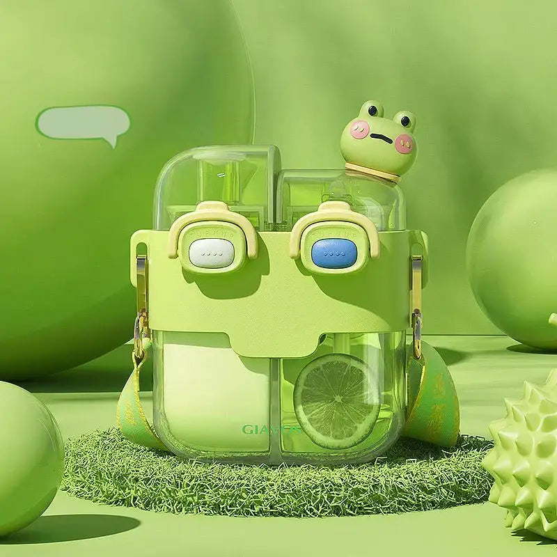 A lime green frog-themed double-bin sippy cup with a transparent body and a pink-nosed frog figurine on top