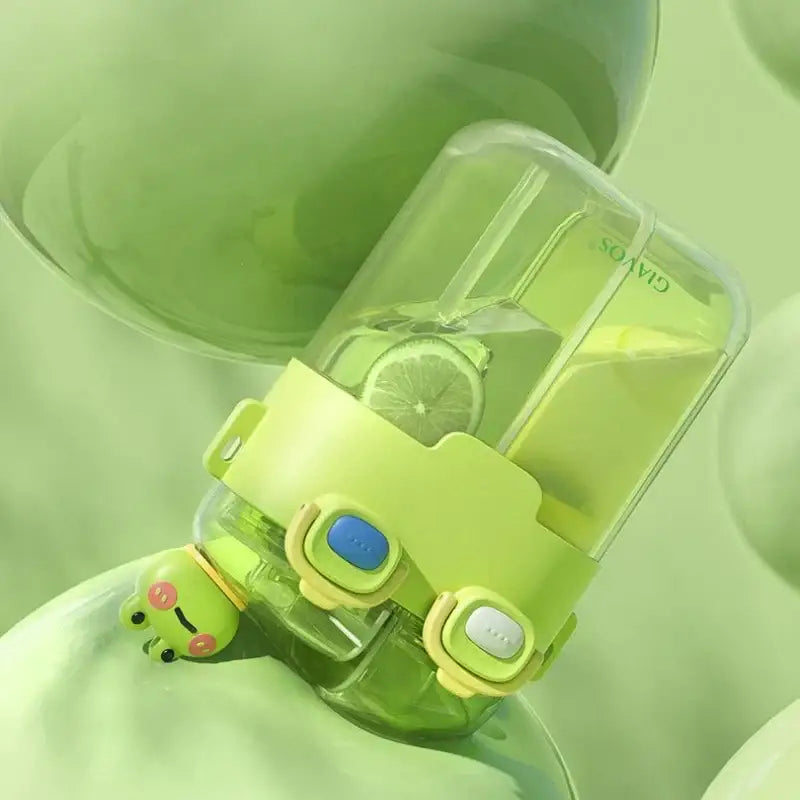 A lime green transparent plastic double-bin sippy cup with matching lid and two blue buttons for kids use