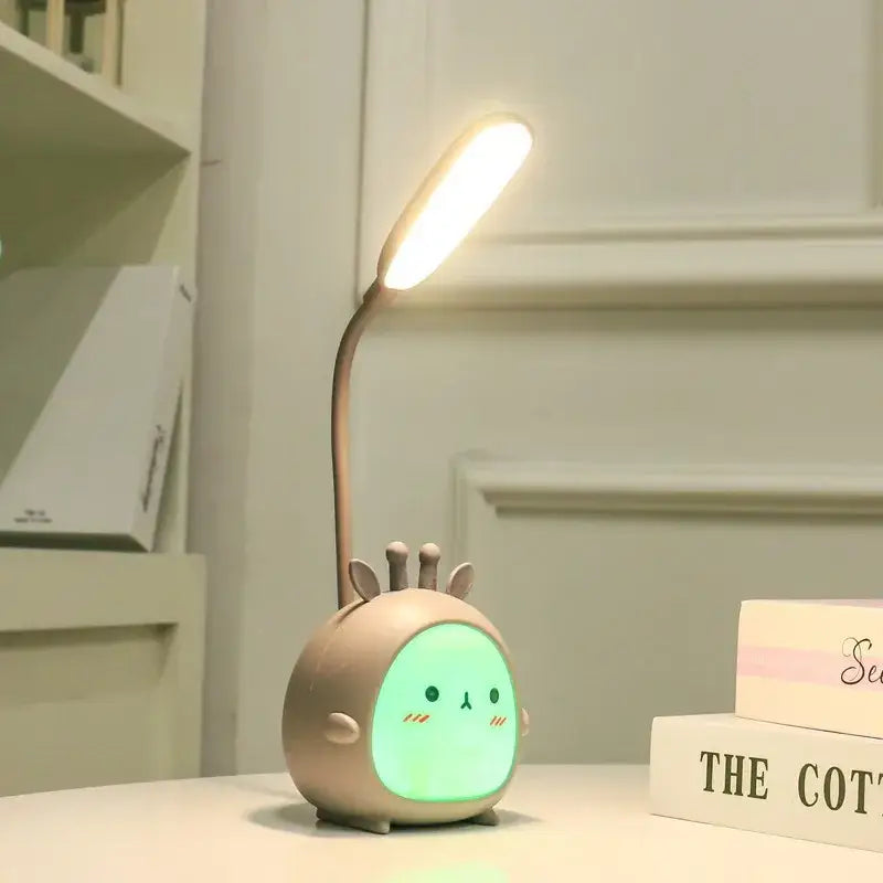 Cute beige giraffe-shaped decorbites cartoon led desk lamp with glowing green face and flexible neck night light