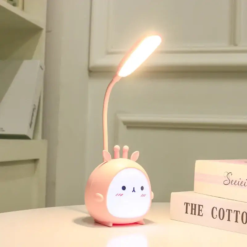 Pink round cartoon led desk lamp shaped like a rabbit with flexible neck glowing as a night light decorbites cartoon led