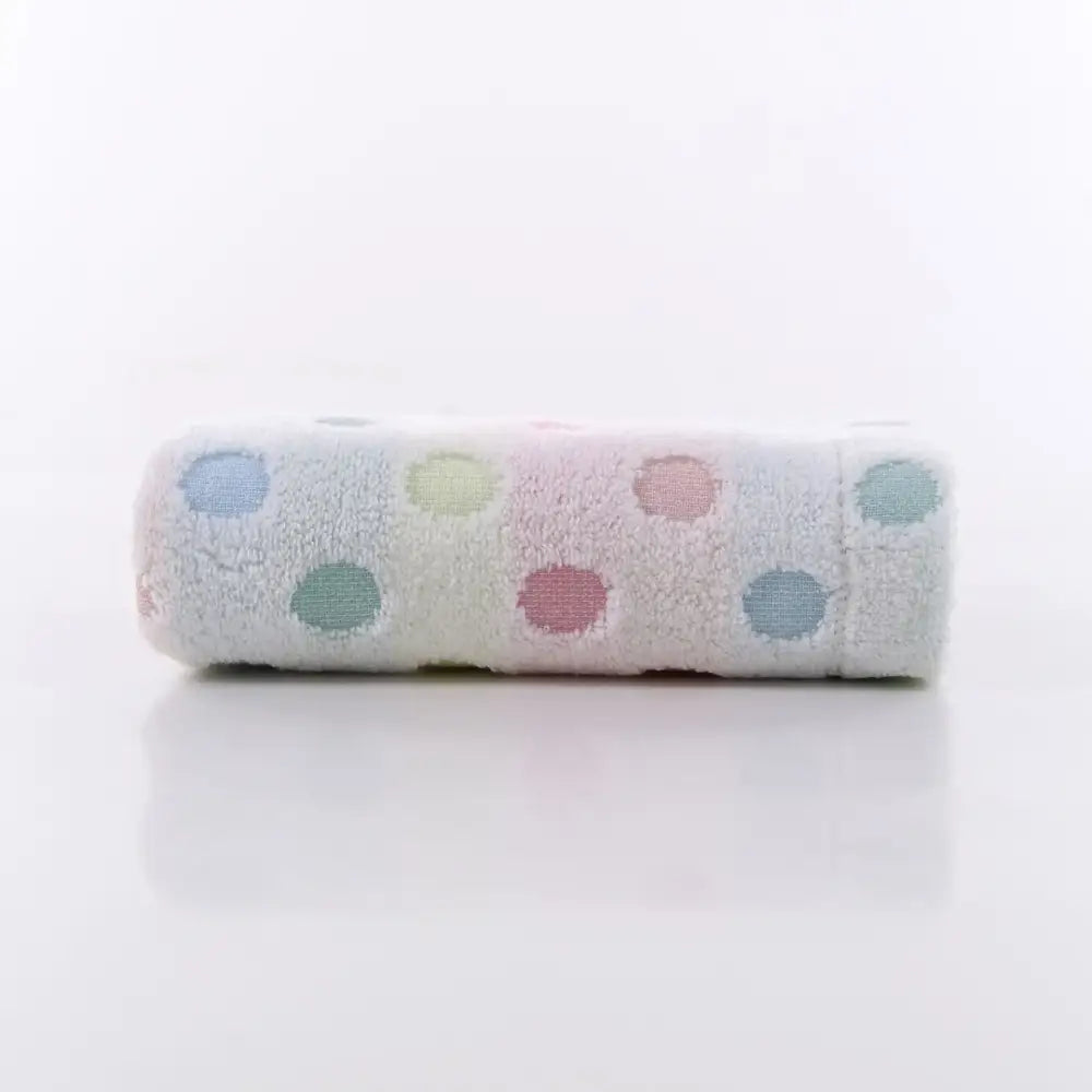 A soft off-white cotton dot face towel with pastel blue pink green and yellow polka dots from decorbites face towel set