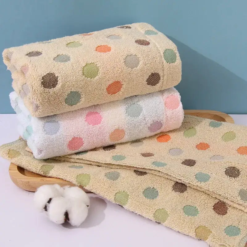 Stacked plush cotton face towel set with soft pastel polka dots in orange green and brown on creamy beige decorbites dot face
