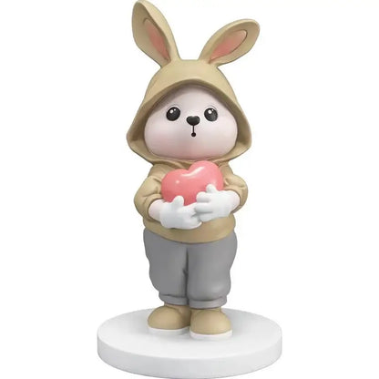Cute beige rabbit desk figurine wearing a hooded sweatshirt holding a pink heart for home decor use
