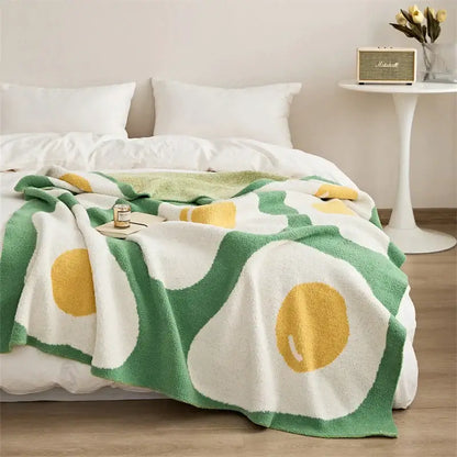 A cozy plush knit poached egg blanket in green and yellow on white for bedroom decorbites cute poached decor