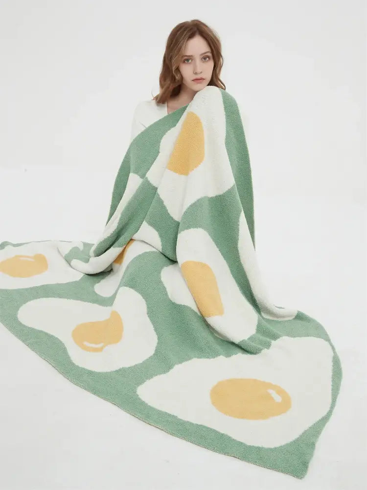 A mint green knitted throw decorated with a cute poached egg pattern ideal for bedroom decorbites decor