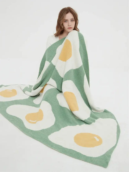 A mint green knitted throw decorated with a cute poached egg pattern ideal for bedroom decorbites decor