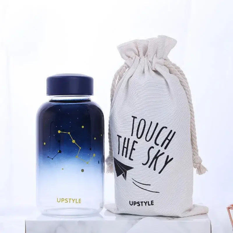 A navy blue gradient decorbites blue glass water bottle with constellation design and gold accents for kitchen use