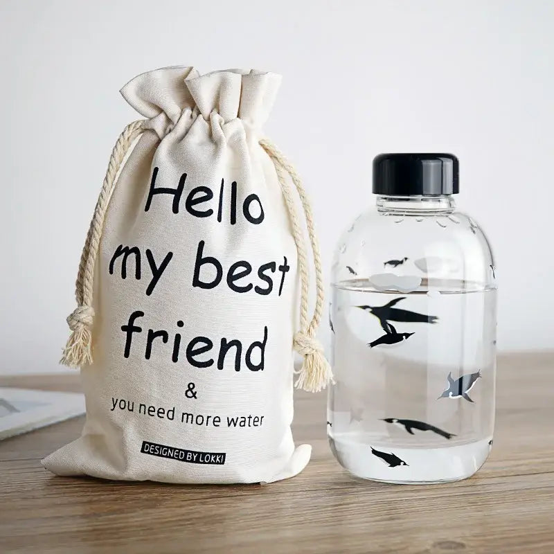 Cream-colored canvas drawstring bag with lokki label alongside cute polar bear and seal decorbites blue glass water bottle