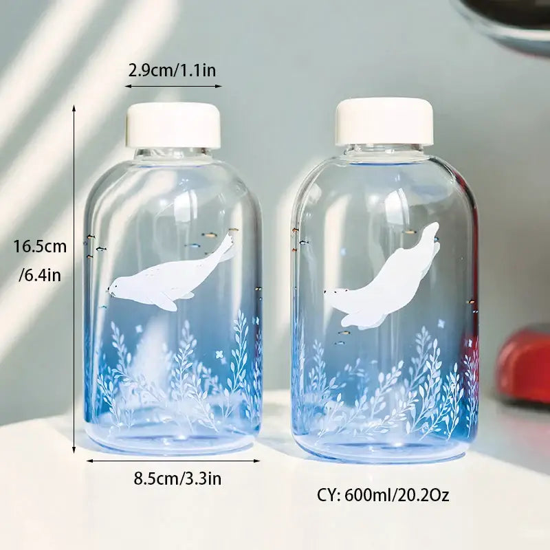 Clear glass decorbites blue glass water bottles with white seal illustrations and blue gradient detailing for drinkware