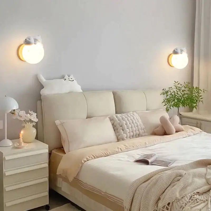 Cream-colored tufted headboard with soft upholstered panels and plush white cat pillow featuring decorbites cartoon animal wall light