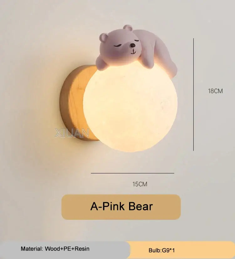 A soft pink polar bear cartoon animal wall light perched on a glowing spherical lamp with wooden base decorbites cartoon animal