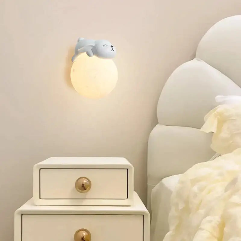 A soft glowing spherical wall light with a cute gray seal figurine for decorbites cartoon animal bedroom lighting