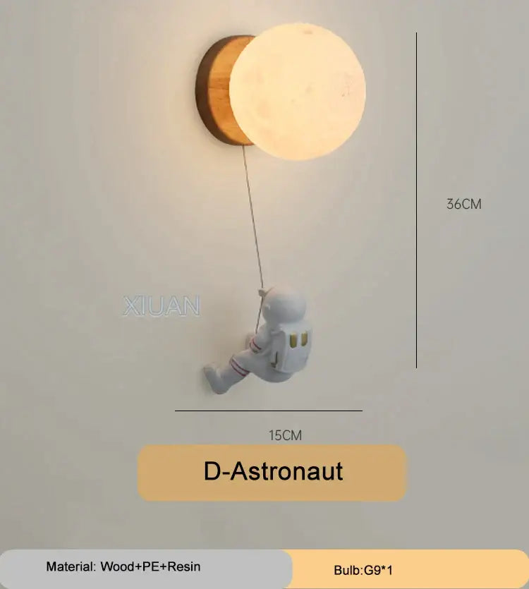 A white wooden and resin astronaut figurine with red stripes hangs from a wooden base holding an illuminated cartoon animal wall light