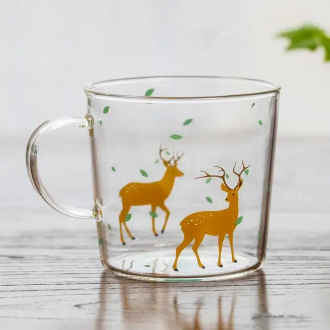 Clear glass coffee mug with two golden deer and green leaves decorative design heat resistant for tea and coffee