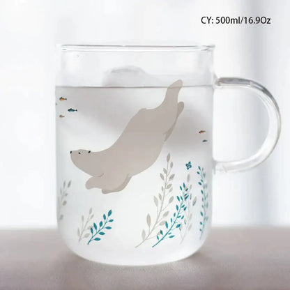 A clear frosted glass coffee mug with a beige seal and teal botanical design heat resistant for kitchen use