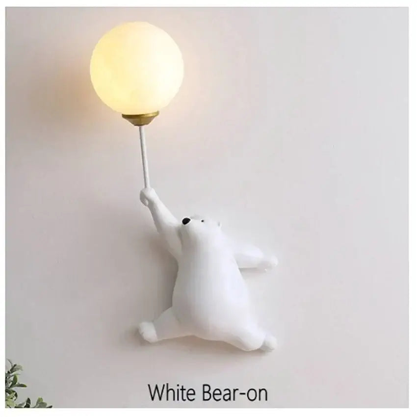 White matte finish bear wall lamp holding a glowing spherical bulb on a slender stem for bedroom lighting