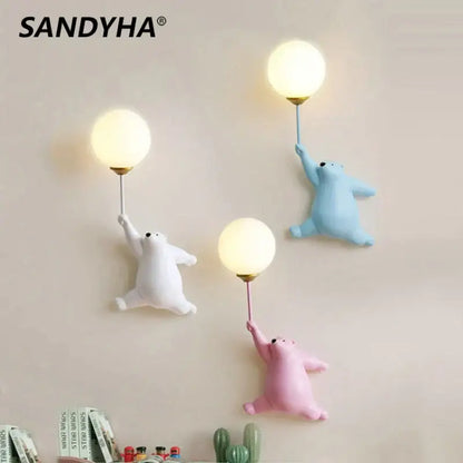 Sandyha bear wall lamp featuring three cartoon polar bears in white blue and pink holding glowing bulbs for bedroom use