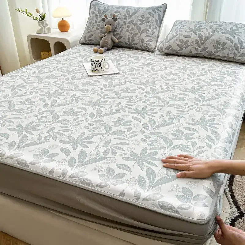 A soft white mattress set sheet with gray leaf pattern elastic edges made of decorbites cooling ice silk material