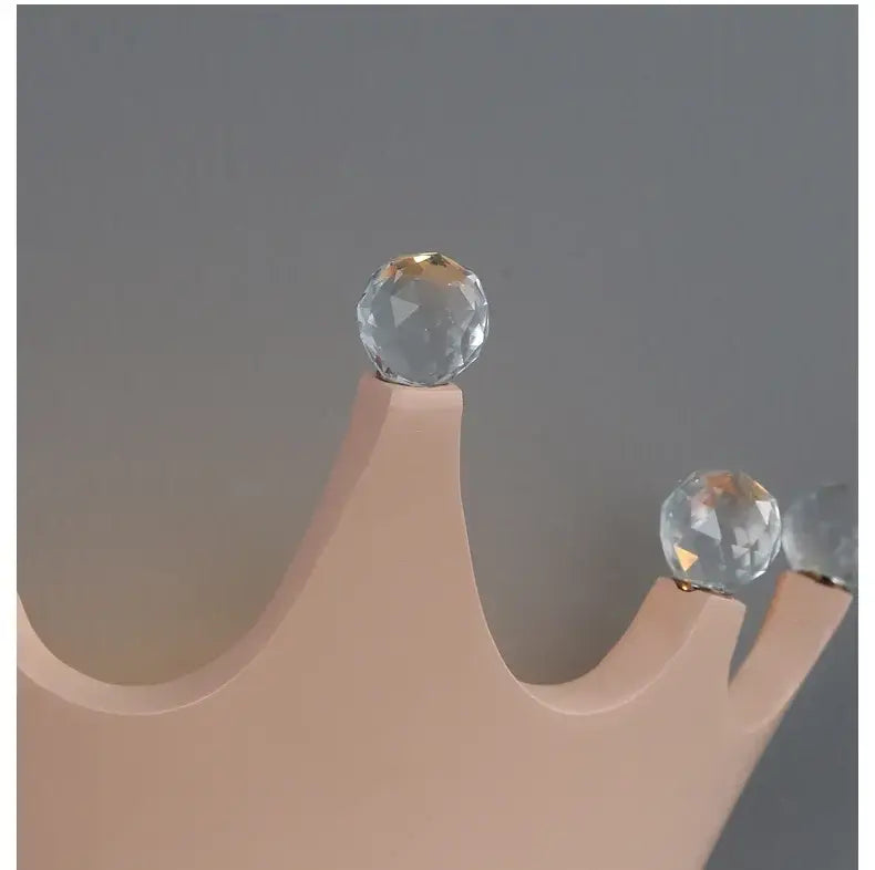 A peach-colored wooden wall sconce crown with faceted clear crystal orbs from decorbites cute resin crystal collection