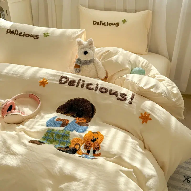 Cream-colored duvet cover with embroidered cartoon characters and delicious in brown lettering from decorbites cartoon embroidery bed sets