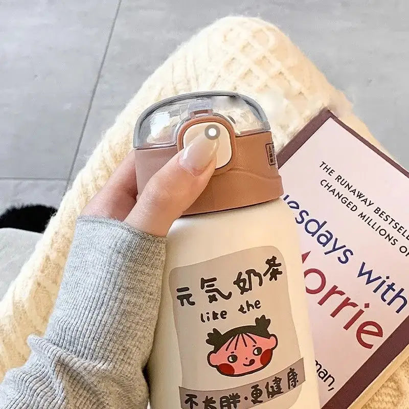 Cream-colored insulated thermos cup with tan lid and cute cartoon sticker featuring chinese characters for travel use decorbites cute straw thermos