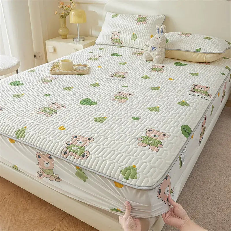 White quilted fitted sheet with cute cartoon pattern of pink teddy bears in green outfits and leaf motifs cooling design