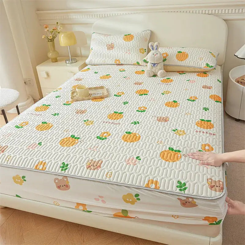 White quilted fitted sheet with cute cartoon pattern of orange fruits and animal faces in soft pastel tones cooling design