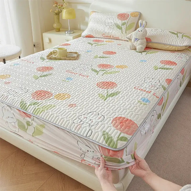 White quilted fitted sheet with cute cartoon pattern of floral and bunny designs and elastic edge for snug fit