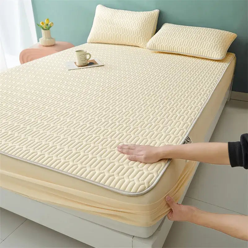 Cream-colored quilted mattress pad with elasticized edges paired with cute white floral cartoon pattern cooling fitted sheet