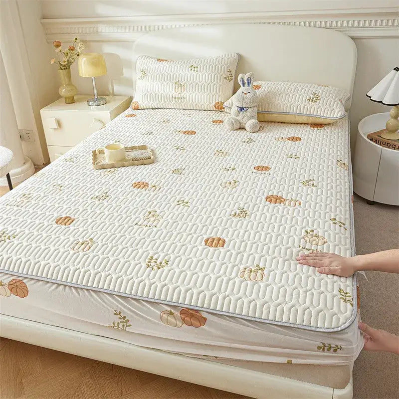 Cream-colored quilted bed pad with subtle pumpkin and leaf pattern complements cute cartoon pattern cooling fitted sheet