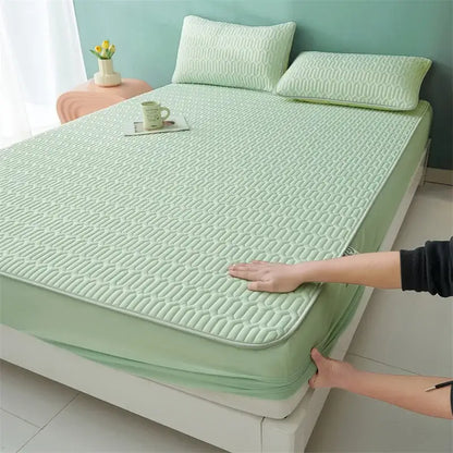 Light green quilted mattress pad with elastic edge paired with cute cartoon pattern cooling fitted sheet for bedroom use