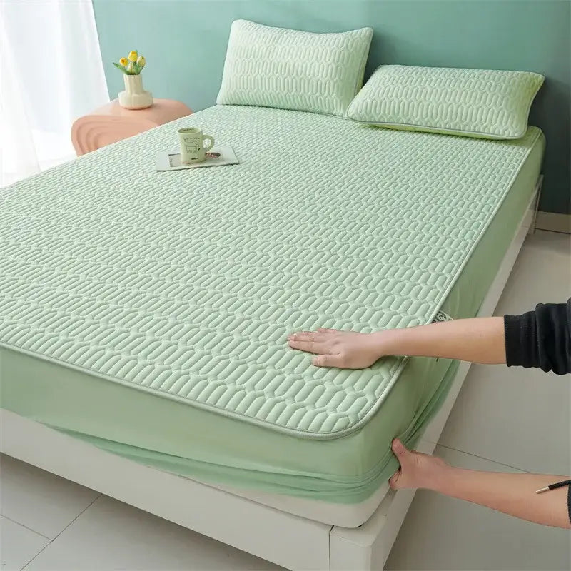 Light green quilted mattress pad with elastic edge paired with cute cartoon pattern cooling fitted sheet for bedroom use