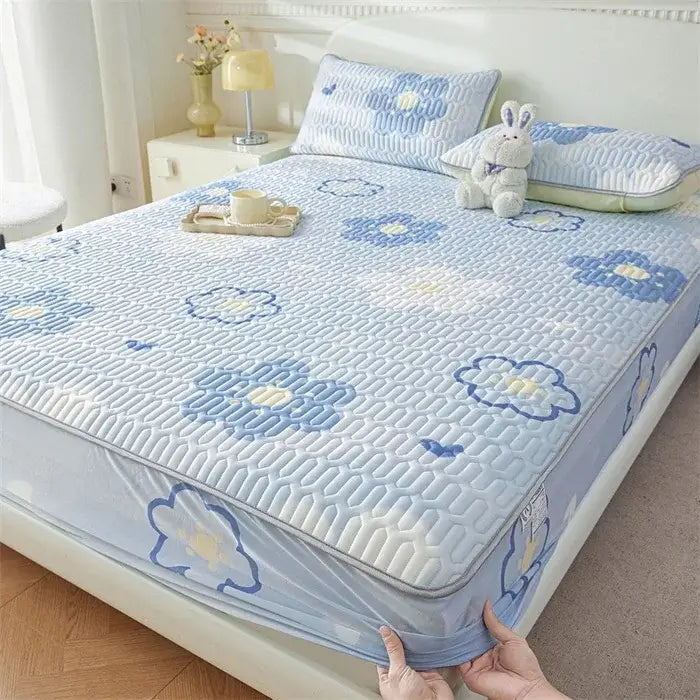 Light blue quilted fitted sheet with embroidered blue and yellow floral patterns featuring a cute cartoon pattern cooling design