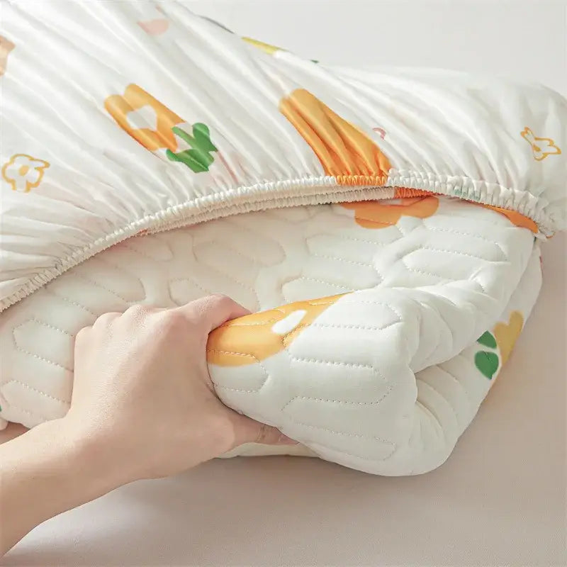 A soft white quilted baby blanket with a cute cartoon pattern cooling fitted sheet floral design in orange and green