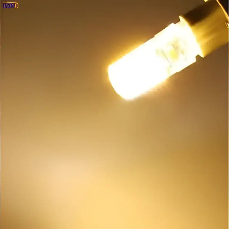 A warm glowing led g9 bulb with clear glass casing and metallic base for decorbites 3w led kitchen lighting pack