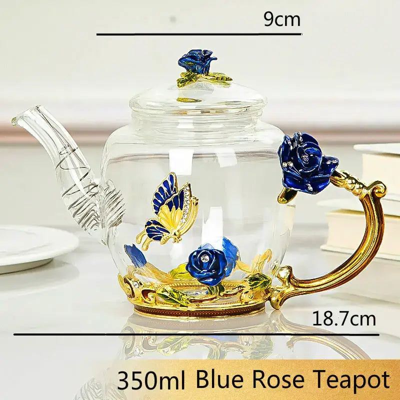 A clear glass teapot set with ornate gold accents blue roses and butterfly motif from daisy enamel pink crystal glass collection