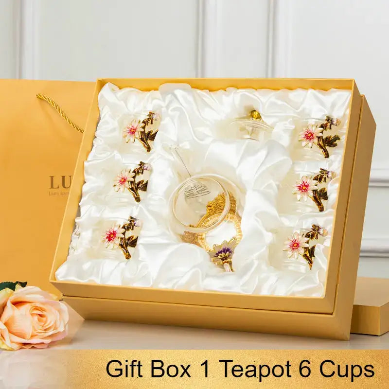 Gold-toned glass teapot set with ornate floral detailing and matching gold-rimmed cups in elegant gift box for dining room