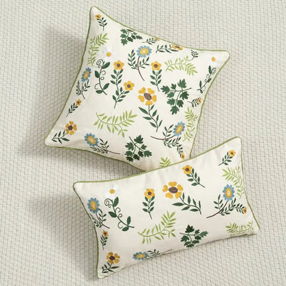Cream-colored decorbites daisy floral embroidered cushion cover with yellow blue green pattern and olive-green piping
