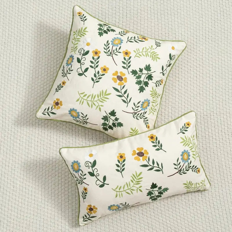 Cream-colored decorbites daisy floral embroidered cushion cover with yellow blue green pattern and olive-green piping