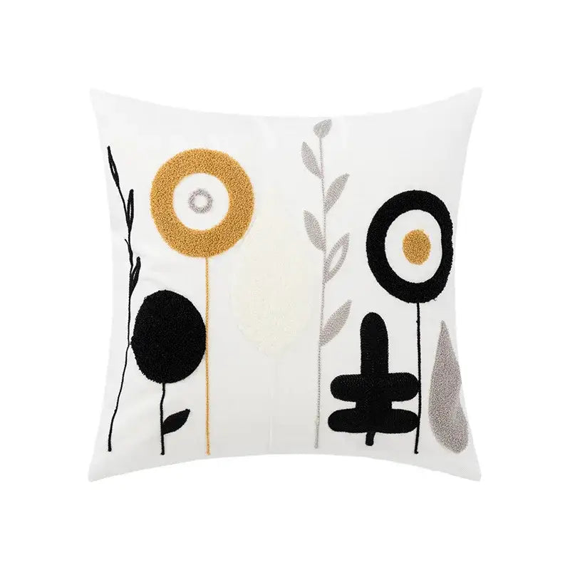 White throw pillow with daisy floral geometric embroidery in black gold and silver textured yarn for living room decor