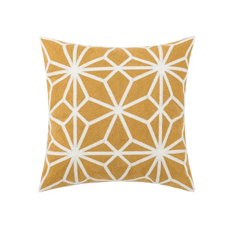 A square throw pillow with mustard yellow base and white geometric embroidery starburst patterns for decorbites daisy floral geometric decor